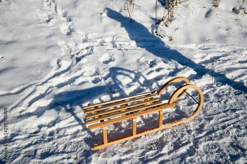 Germany, North Rhine-Westphalia, Eifel, shadow of person next to sledge in winter landscape photo