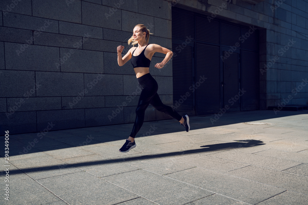 Young woman in black sportswear training running Young woman in black sportswear training running