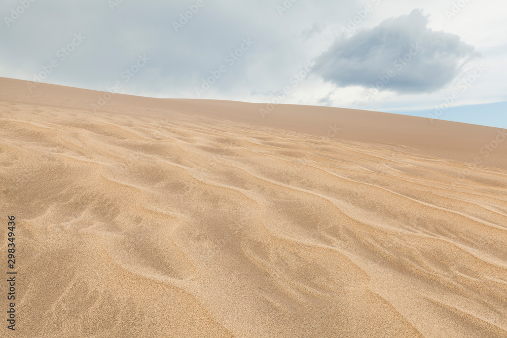 Ripples on sand dune with cloud overhead Ripples on sand dune with cloud overhead