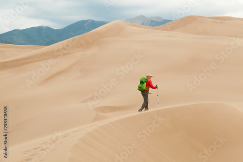 Wallpaper Mural Senior man hikes windswept ridge on sand dune Torontodigital.ca