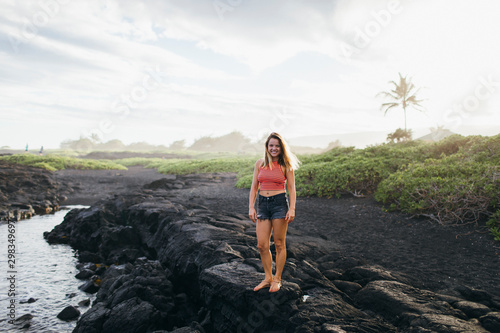 A girl walking on lava rocks near the ocean, Big Island, Hawaii photo