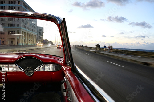 The Malecon in Havana in Cuba from a classic convertible red car photo
