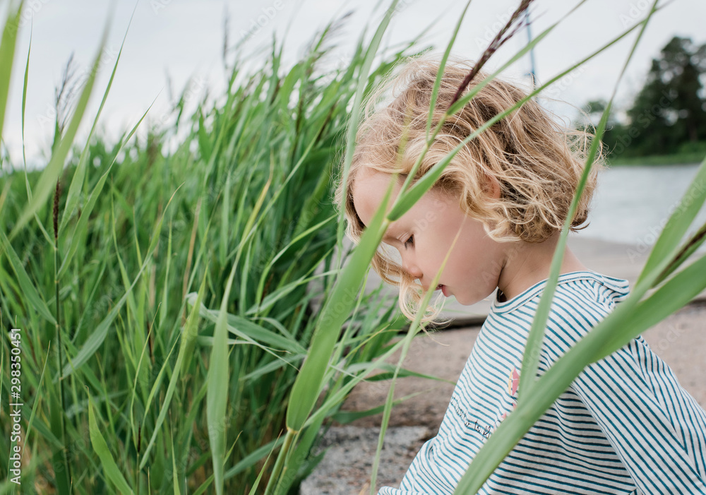 Portrait of a young girl sat in the grass at the beach on vacation Portrait of a young girl sat in the grass at the beach on vacation