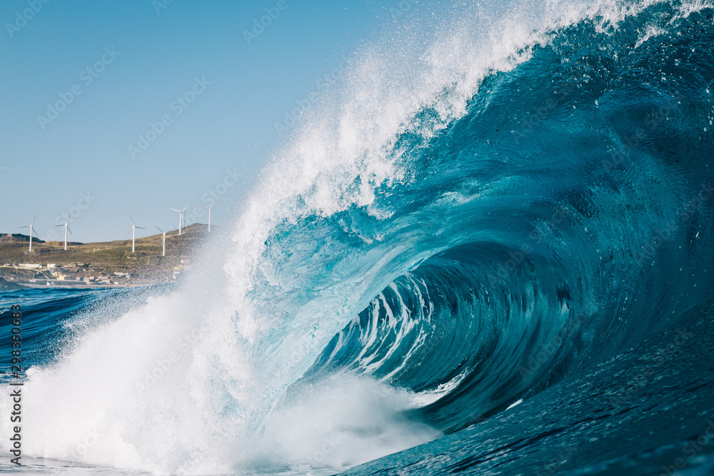 Heavy wave breaking with mountains in the background Heavy wave breaking with mountains in the background