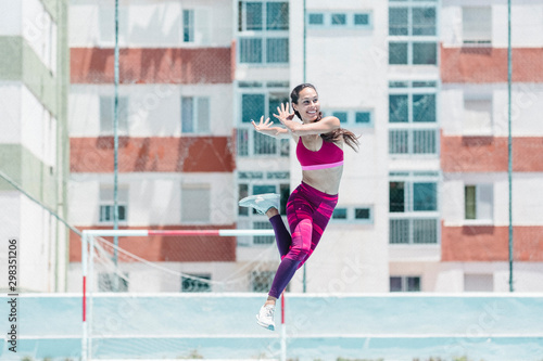 Colorful image of full body of female athlete jumping on court photo