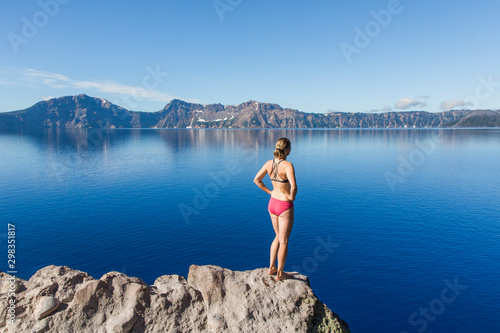 A young woman stands on the rim of Crater Lake photo