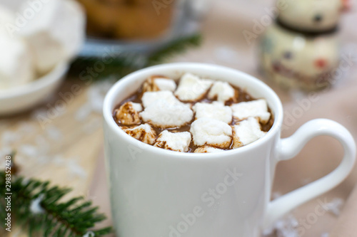 hot cocoa with marshmallows in white mug, cream and cookies on holiday christmas background.