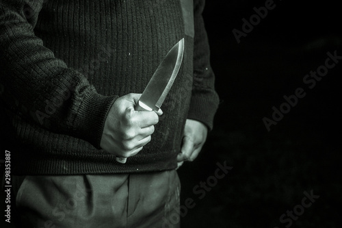 full night. a man holding a knife. close-up. concept of violence.