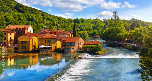 Borghetto Valeggio sul Mincio, Verona, Italy. Italian traditional village with vintage colorful houses above river. Stone bridge among ancient architecture. Flowers and greens. Summer sunny day. photo
