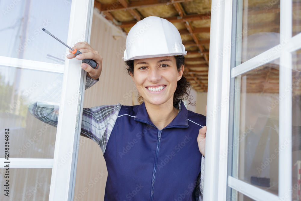 young woman builder looking outside the window young woman builder looking outside the window