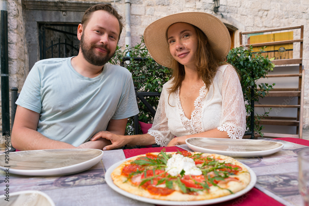 young smiling couple before eating pizza