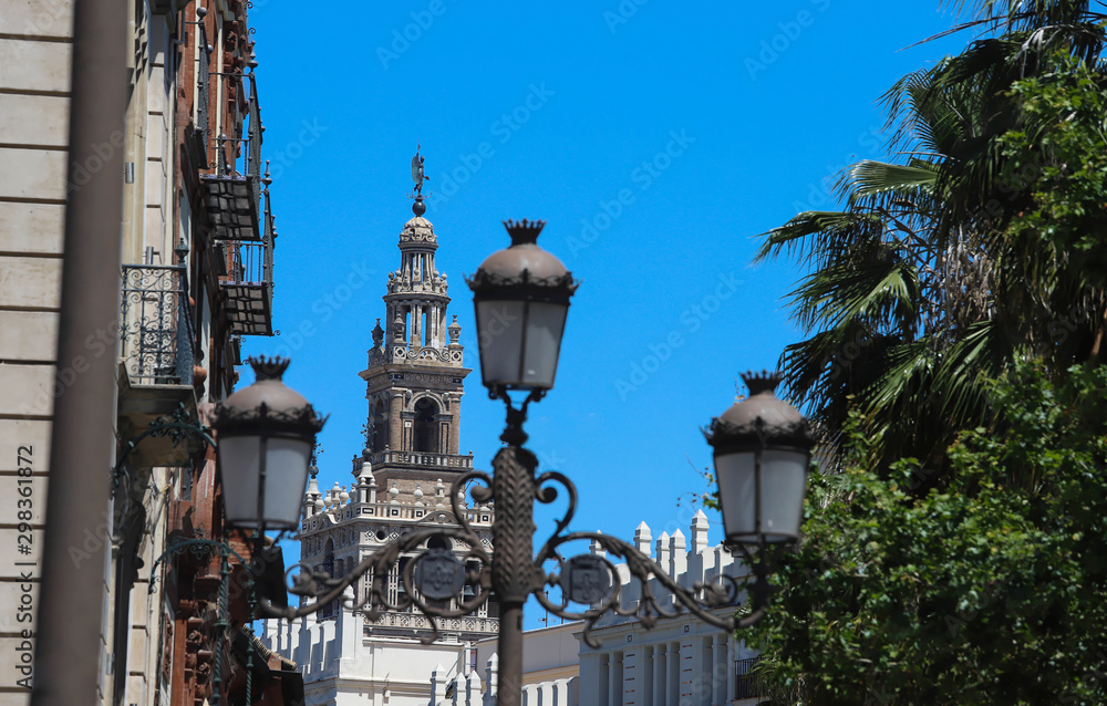 The Giralda, the bell tower of the Cathedral of Seville and traditional lamp post in the foregrond, Seville, Spain.