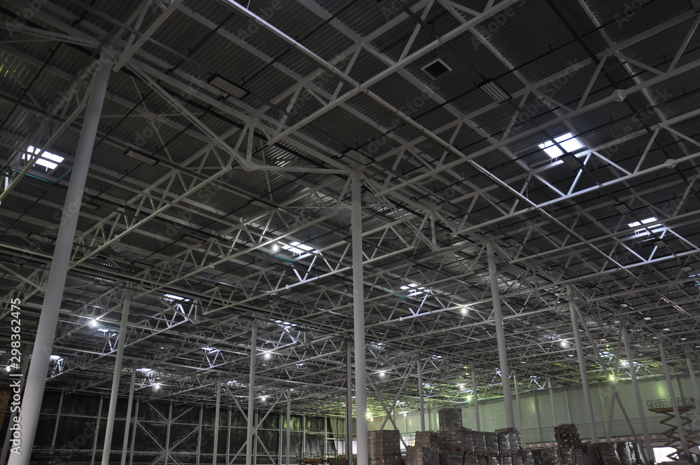 Construction of a warehouse complex, inside view. Columns are installed, crushed stone is laid on the floor.
