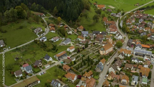 Aerial view of the village Oberwolfach in Germany on a cloudy day in autumn, fall. Pan to the left above the church. photo