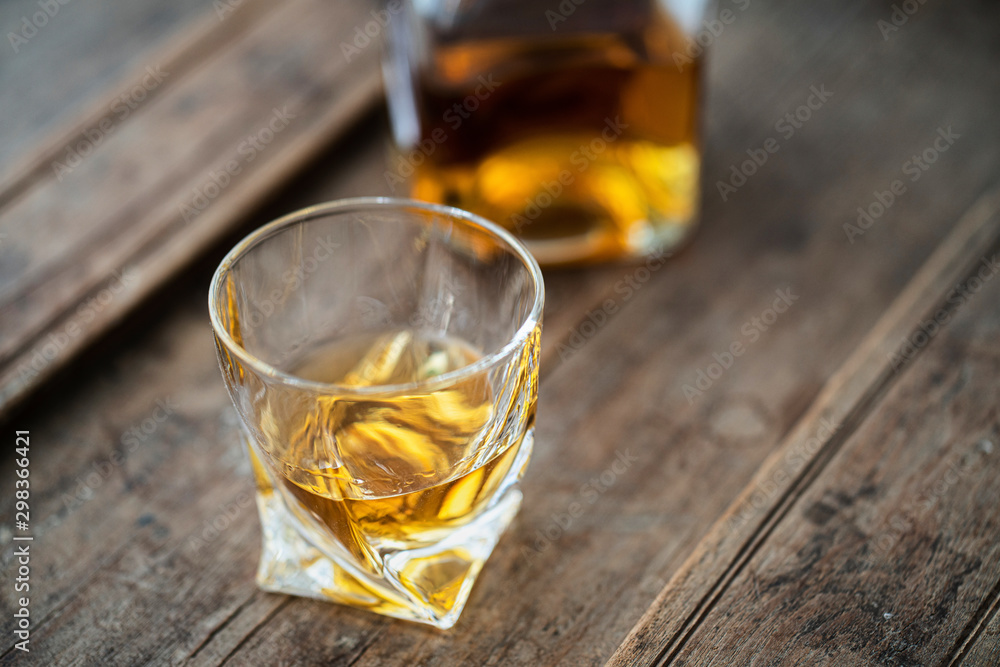 Close up of whisky glass and bottle in beautiful light Close up of whisky glass and bottle in beautiful light