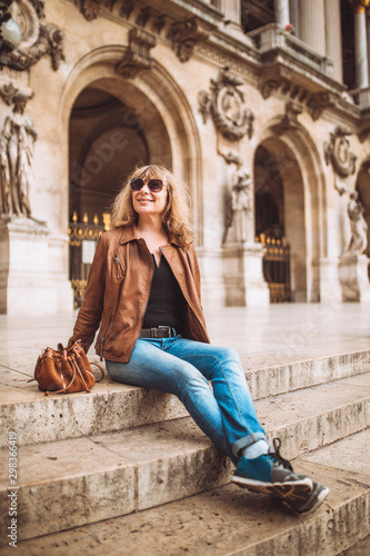 nice tourist girl with glasses on the marble steps of the grand opera in paris