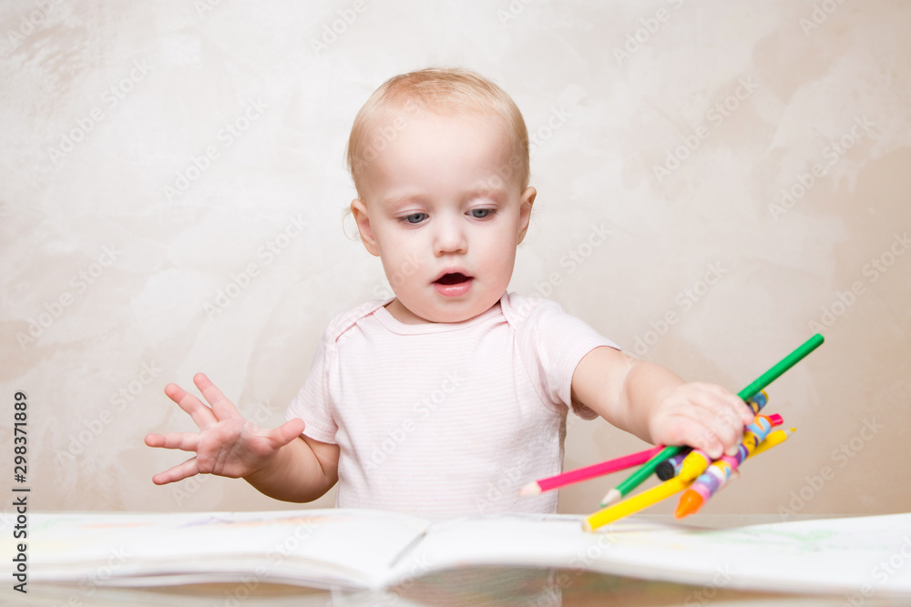 child pokes a bunch of pencils and crayons into a sketchbook child pokes a bunch of pencils and crayons into a sketchbook