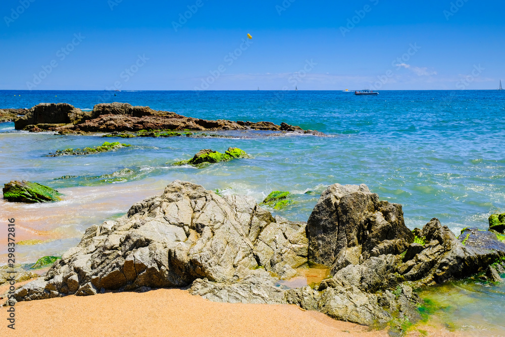 Rocks on the beach near the city beach in Lloret de Mar, Costa Brava. The concept of rest.