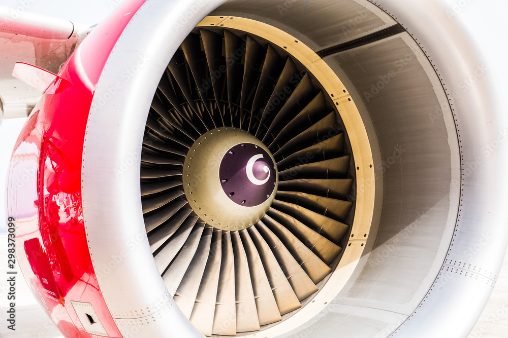 High detailed closeup view on jet airplane engine with red cowling and white background