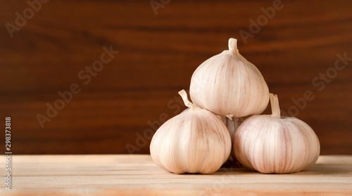 Garlic bulbs  on wooden table and dark background with copy space,food ingredient benefit for reducing blood pressure and improves blood cholesterol levels,selective focus
