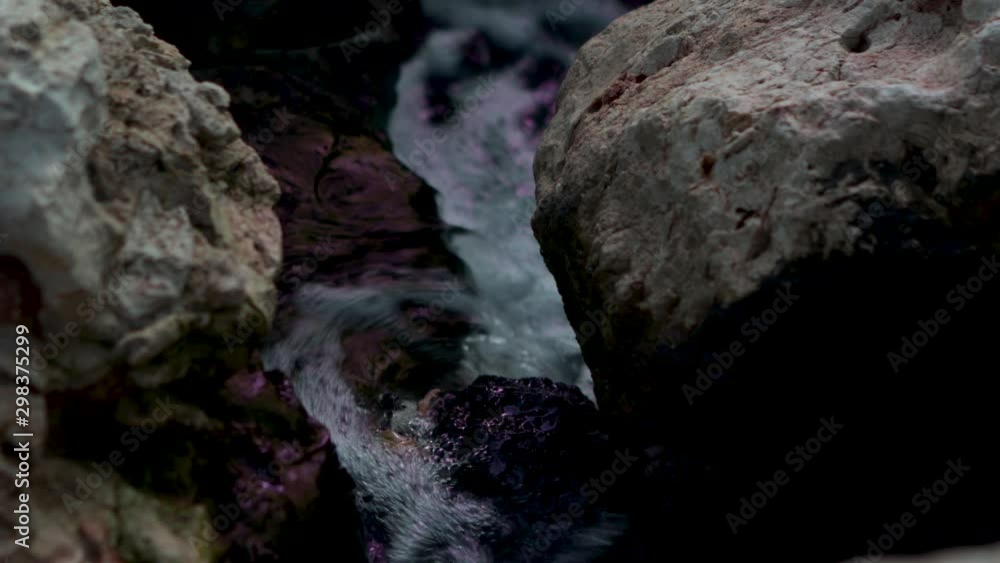 Close up of a natural stream of water, making it's way through stones, close to reaching the sea. Close up of a natural stream of water, making it's way through stones, close to reaching the sea.
