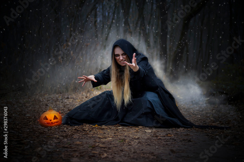 Pretty blonde in a witch costume for Halloween. Fototapeta