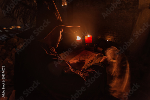 Nostradamus writing his prophesies, fantasy concept. illuminated by candles, long exposure, motion blur, high ISO photo