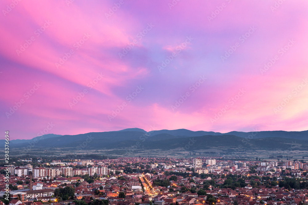 View of Pirot, Serbia from a vantage point with city lights, car trails and beautiful, purple sunset sky
