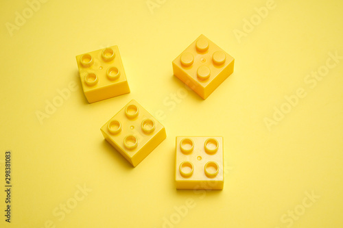 A yellow children s plastic bricks or blocks toy on yellow background