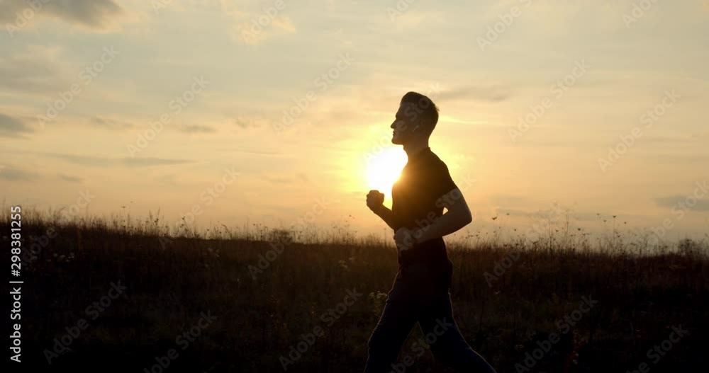 Young guy is running off-road at sunset in autumn weather 4K 