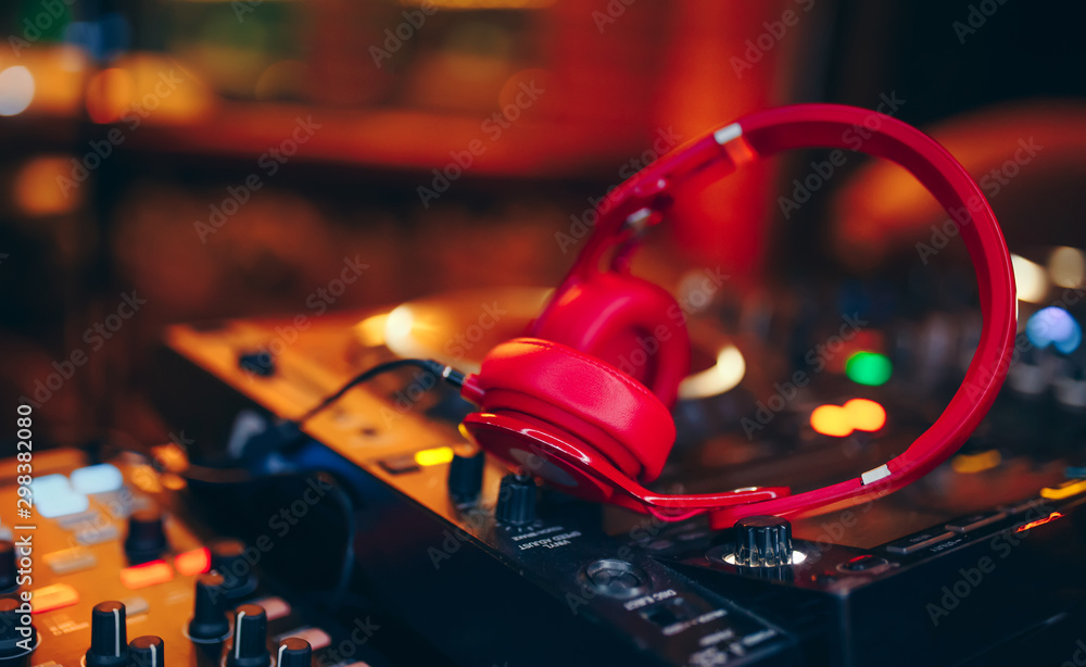 Closeup pair of Cheer red headphones for DJ.cd mp4 music deejay mixing desk  music party in nightclub. Club console for experiments with music. Stock  Photo | Adobe Stock