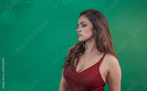 Portrait of young brunette beauty singing with retro microphone,on green background © @Nailotl