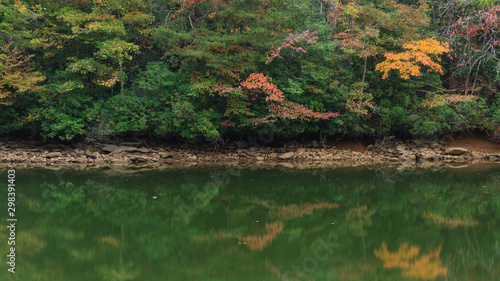 Fototapeta Naklejka Na Ścianę i Meble -  A scenic autumn view of colorful forest foliage reflecting on a lake.