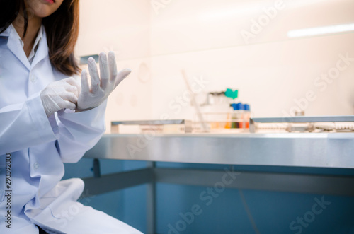 Scientist wear gloves for used chemical solution and equipment lab testing for Bacteria or virus on Fume Hood in laboratory ,Research and Science concept