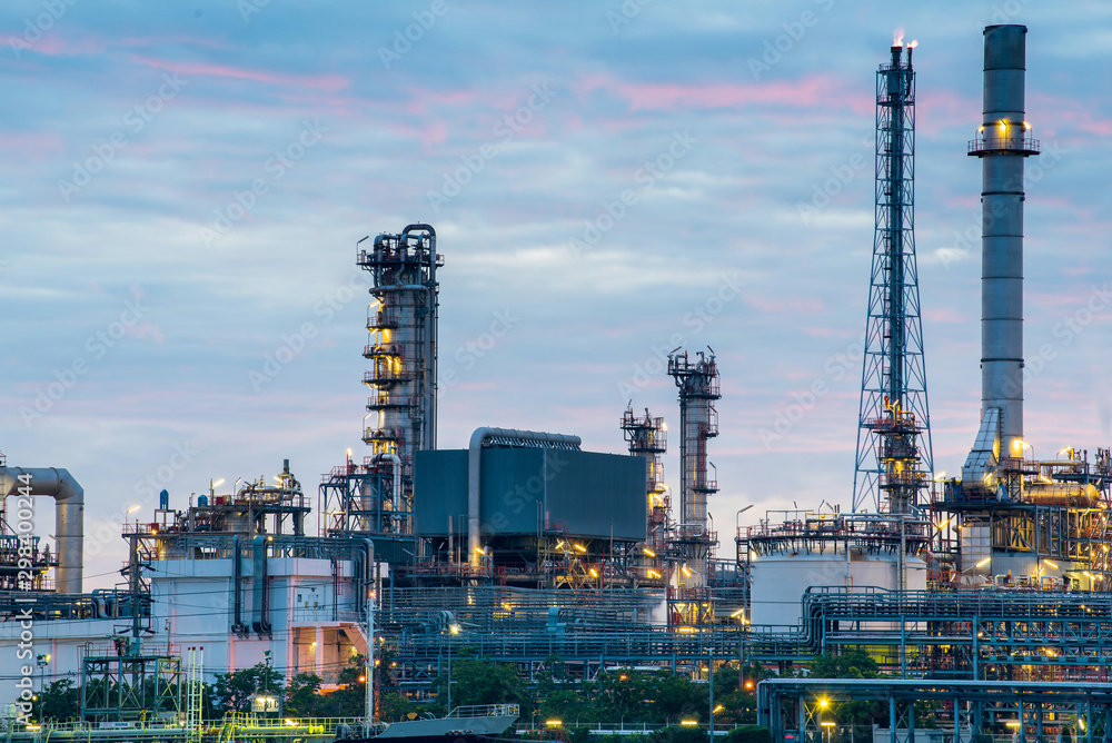 Oil and gas refinery plant area near the river at twilight, sunset time Oil and gas refinery plant area near the river at twilight, sunset time