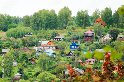 landscape with colorful wooden houses and trees on the banks of the Volga river