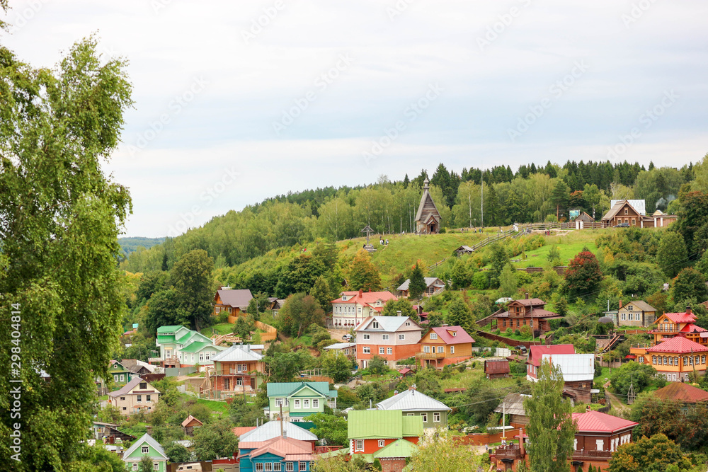 Colorful houses in small russian town Plyos with the wooden church on the hill