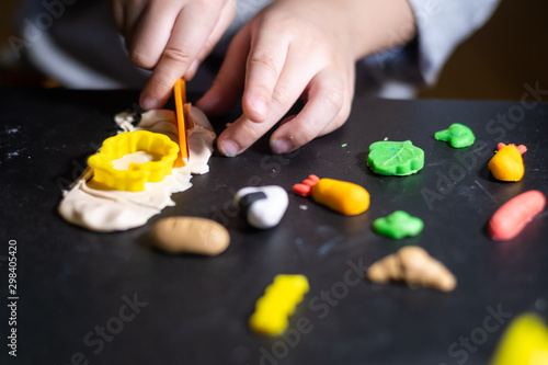 Close up and selective focus of little children hand playing with clay molding shapes foods
