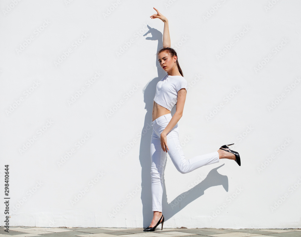 Model tests. Young beautiful brunette model posing against a white wall