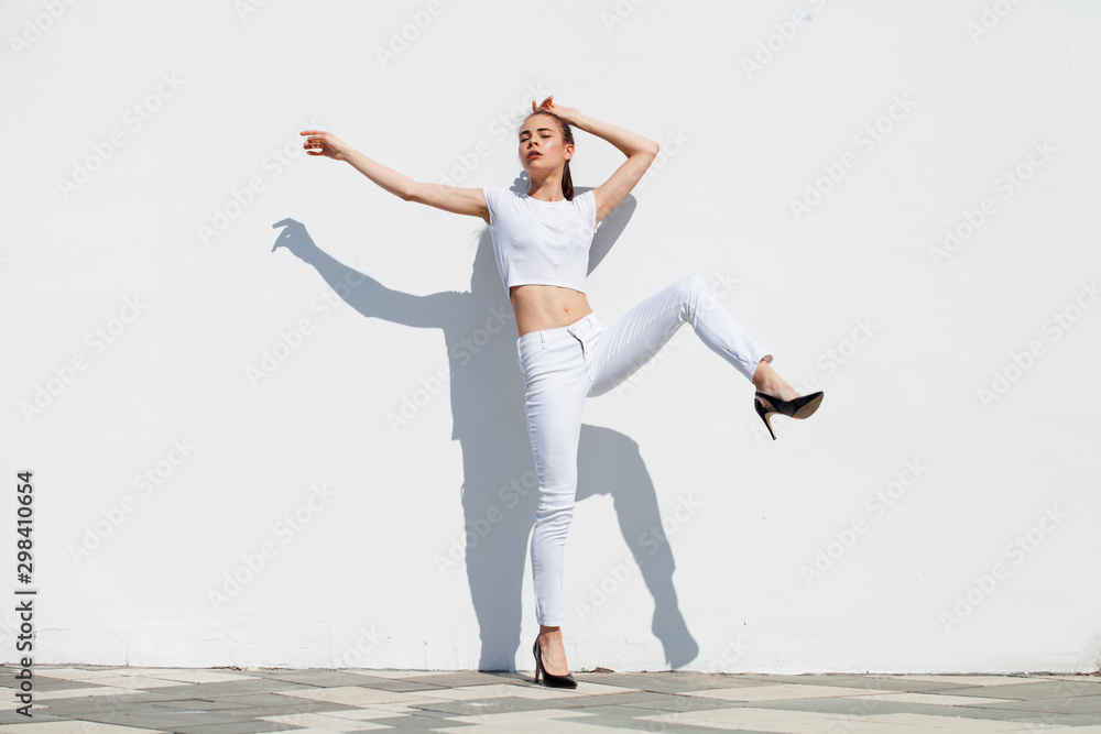 Model tests. Young beautiful brunette model posing against a white wall Model tests. Young beautiful brunette model posing against a white wall