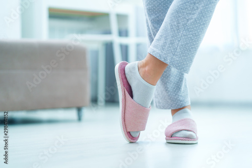 Female legs with cozy soft comfortable home slippers
