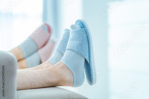 Family couple resting together on the sofa in home cozy soft comfortable slippers