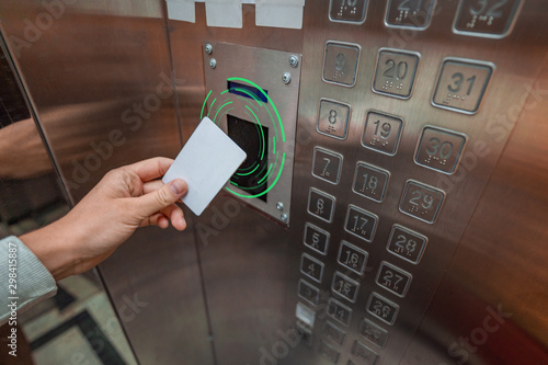 Person using a key card in an elevator