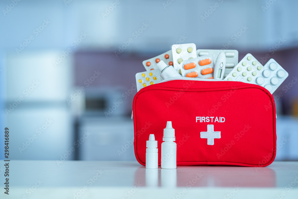 Medical first aid kit with medicine and pills on table at home