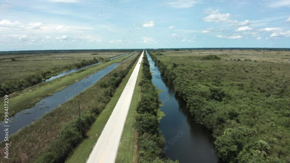 Rural road in central florida next to wetland and canal Rural road in central florida next to wetland and canal
