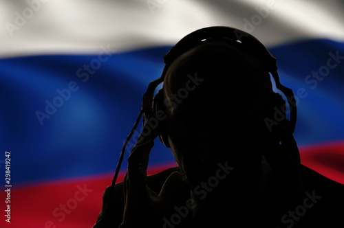 Silhouette of a man in headphones, secret agent eavesdropping, spy and scout, Russian flag, backlight photo