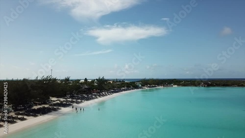 Drone footage flying over beach with  crystal clear water slow  rotation to open sea Bahamas island Half Moon Cay photo