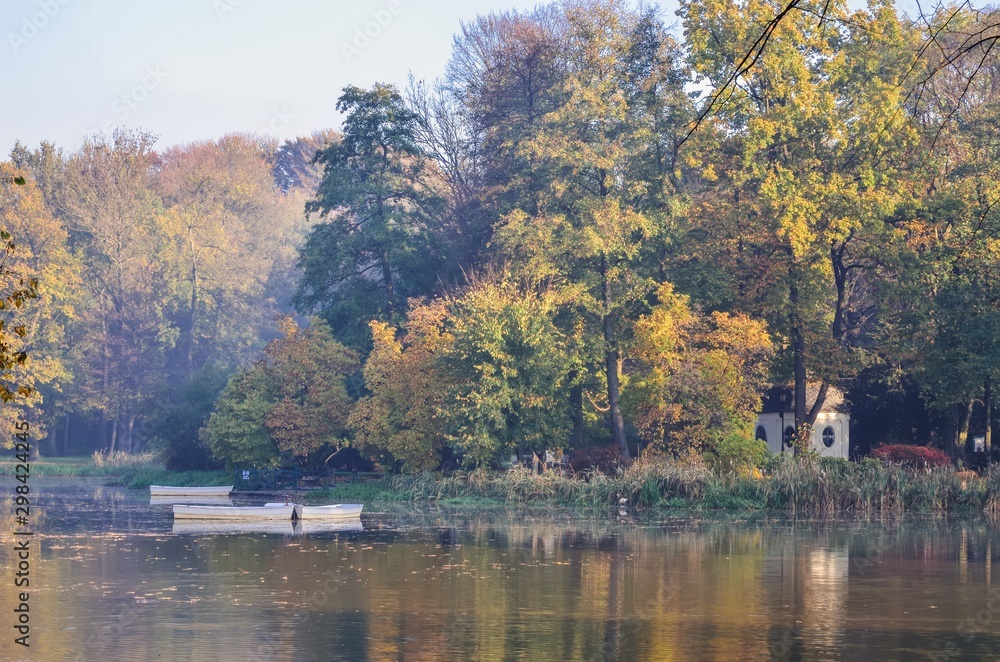 Beautiful autumn colorful landscape. Islet on a pond in the city park in Pszczyna, Poland.