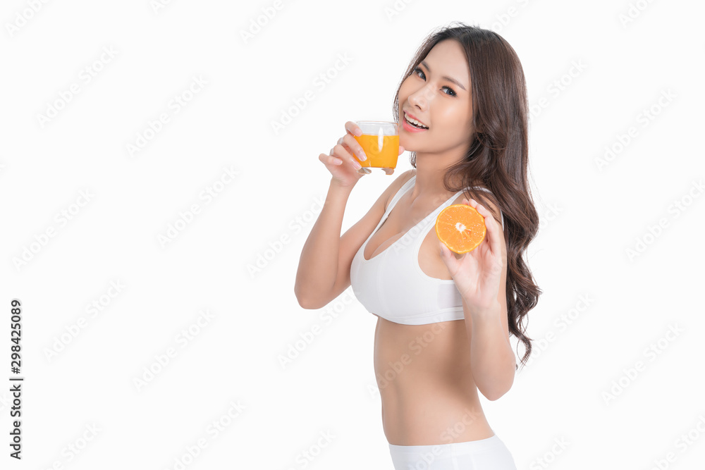 Smiling woman holding orange juice and fruit. Muscular woman's body in white lingerie isolated on white background. Smiling woman holding orange juice and fruit. Muscular woman's body in white lingerie isolated on white background.