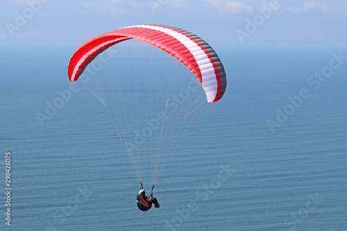 Paraglider flying above the sea